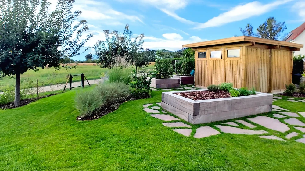 Terrasse extérieure avec verre de vin rouge posé sur table en bois