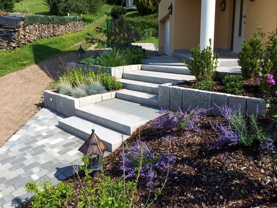 Espace extérieur résidentiel avec piscine rectangulaire à débordement, entourée de dallage en pierre naturelle claire