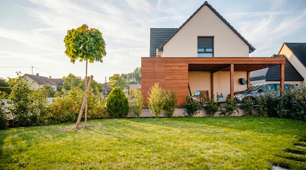 Jardin extérieur avec pergola en bois et mobilier de terrasse sous palmier