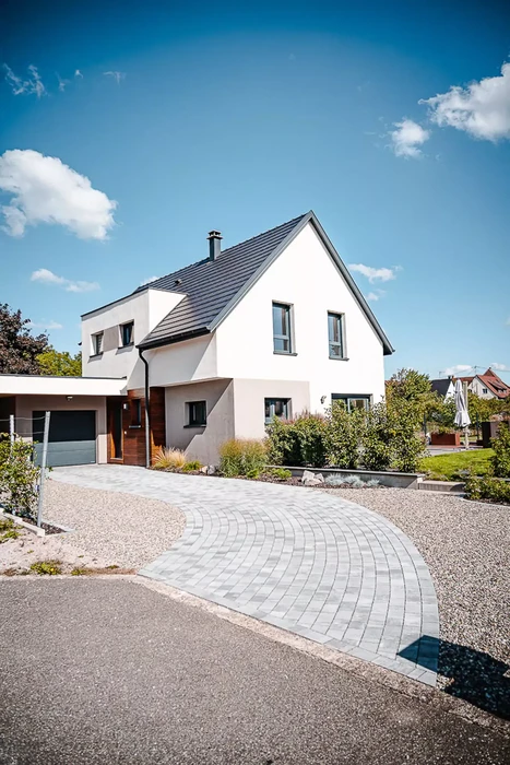 Aménagement paysager extérieur avec massif floral coloré bordant une pelouse verte